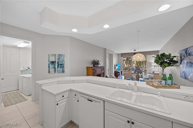 kitchen featuring independent washer and dryer, light tile patterned floors, sink, white cabinetry, and dishwasher