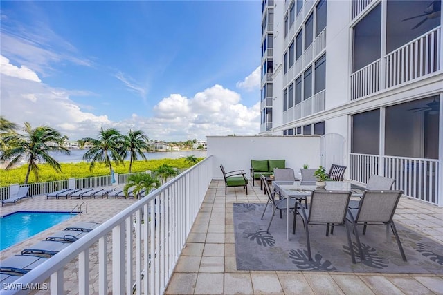 balcony featuring ceiling fan, a water view, a patio area, and outdoor lounge area