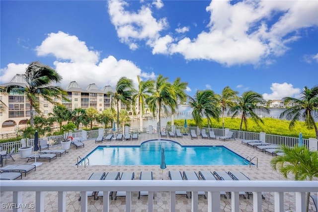 view of swimming pool featuring a patio area and a water view