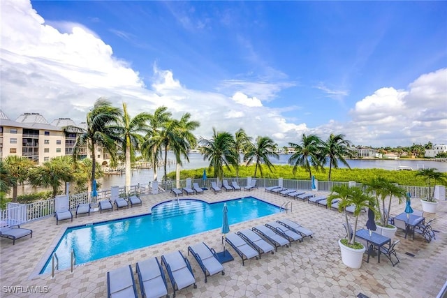 view of pool featuring a patio and a water view