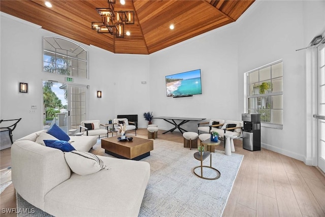 living room with a towering ceiling, light hardwood / wood-style floors, and wood ceiling