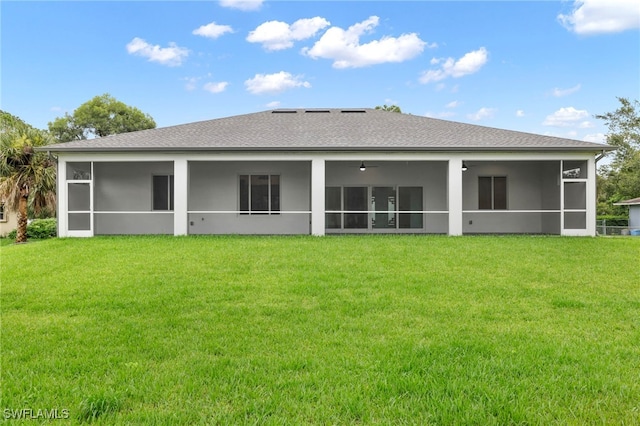 rear view of house with a sunroom and a yard