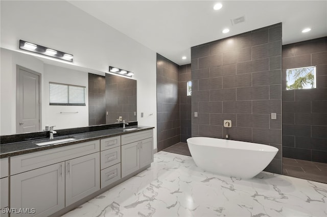 bathroom featuring shower with separate bathtub, vanity, tile walls, and plenty of natural light