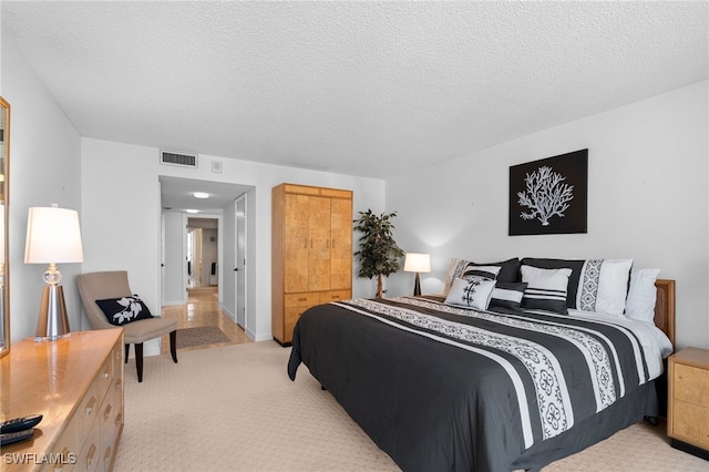 bedroom with light carpet and a textured ceiling