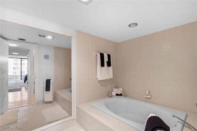 bathroom featuring plus walk in shower, tile walls, and tile patterned flooring