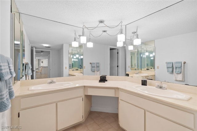 bathroom with vanity, a textured ceiling, and tile patterned floors