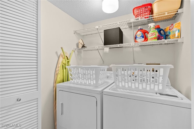 clothes washing area featuring washing machine and clothes dryer and a textured ceiling