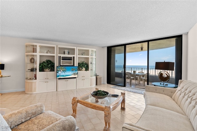 tiled living room featuring a textured ceiling and floor to ceiling windows