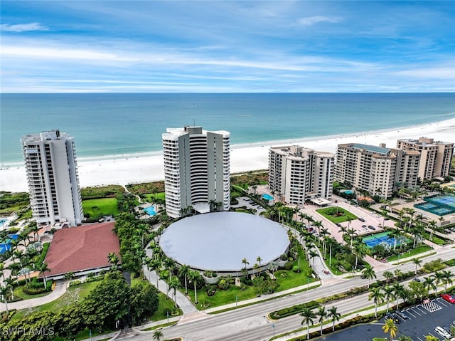 drone / aerial view featuring a beach view and a water view