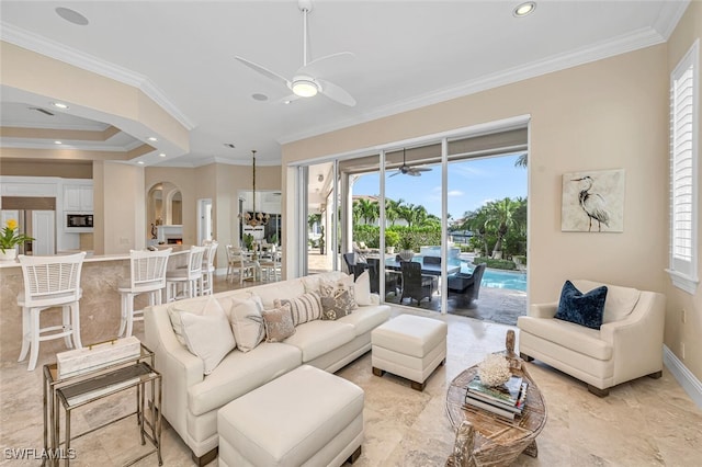 living room featuring ornamental molding, ceiling fan, and a healthy amount of sunlight