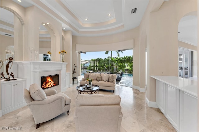 living room featuring a tray ceiling and crown molding