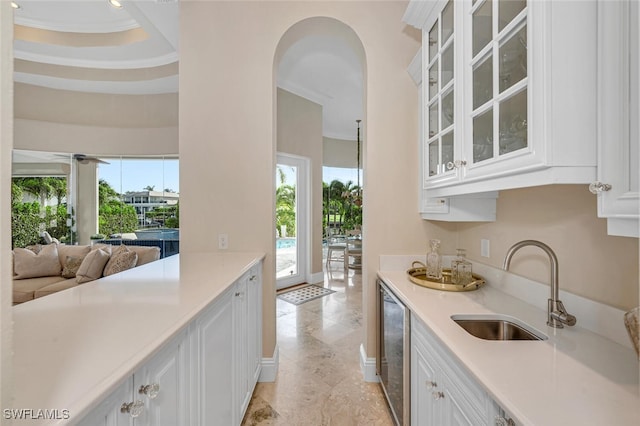 kitchen featuring ornamental molding, white cabinetry, ceiling fan, and sink