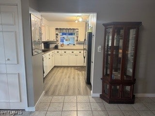 kitchen with fridge, light hardwood / wood-style flooring, and white cabinetry