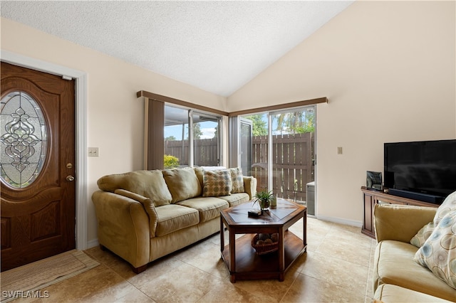 tiled living room with a textured ceiling and high vaulted ceiling