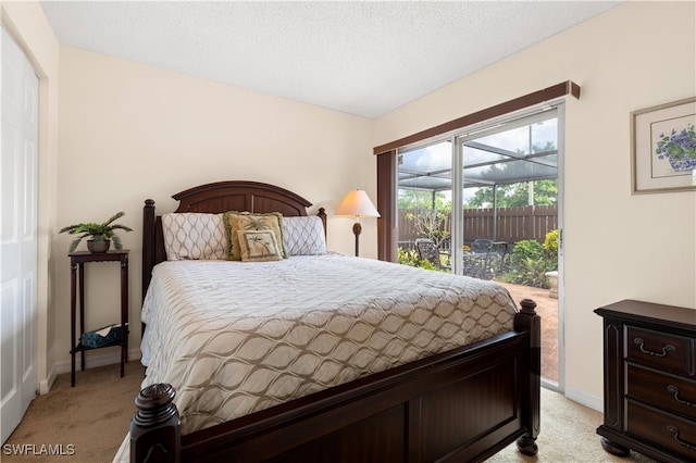 bedroom featuring light carpet, a textured ceiling, and access to exterior