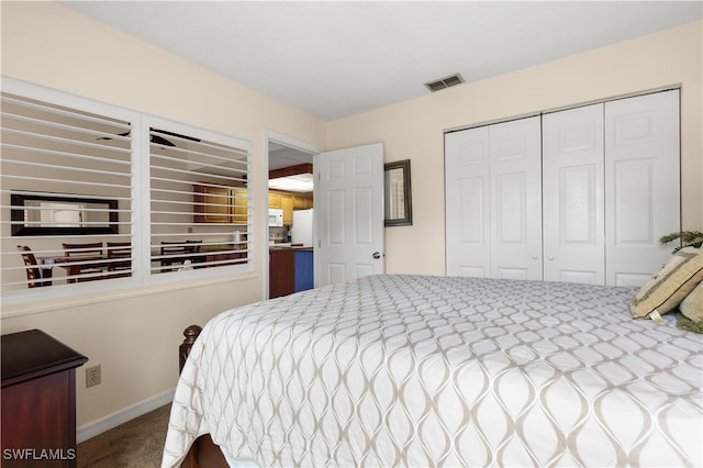 carpeted bedroom with a closet and white fridge