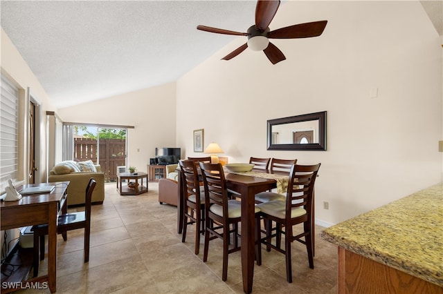 dining space with high vaulted ceiling, ceiling fan, and a textured ceiling