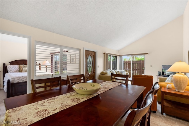 tiled dining space featuring lofted ceiling and a textured ceiling