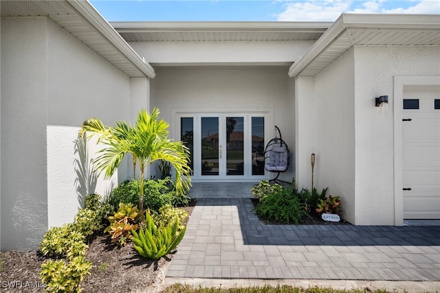 property entrance featuring a garage and french doors