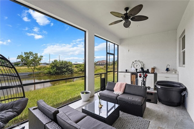 sunroom / solarium with ceiling fan and a water view