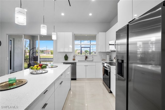 kitchen with appliances with stainless steel finishes, white cabinetry, sink, and pendant lighting