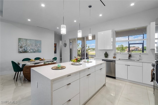 kitchen with white cabinets, hanging light fixtures, sink, stainless steel dishwasher, and a kitchen island