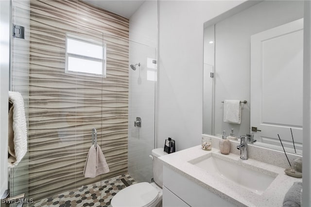 bathroom with a shower with door, vanity, and toilet