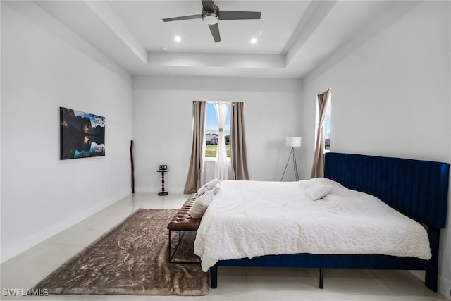 bedroom featuring a raised ceiling and ceiling fan