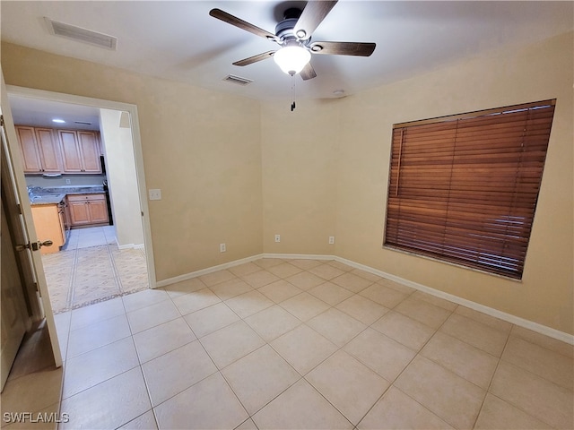 unfurnished room with ceiling fan and light tile patterned floors