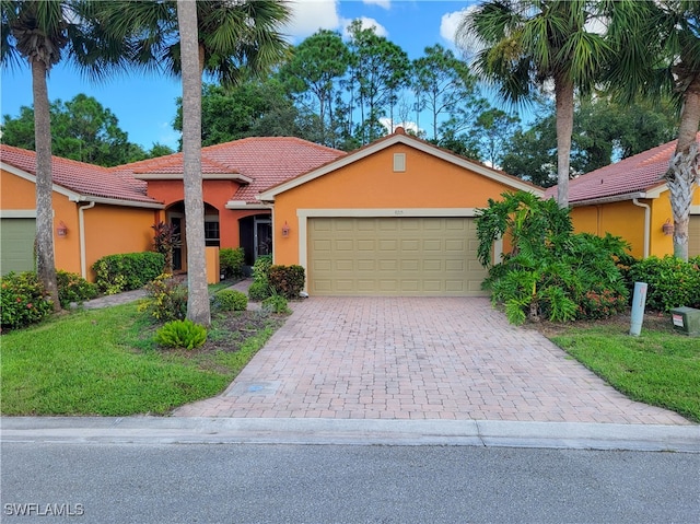 view of front of property with a garage and a front lawn