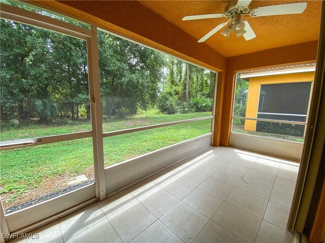 unfurnished sunroom with ceiling fan