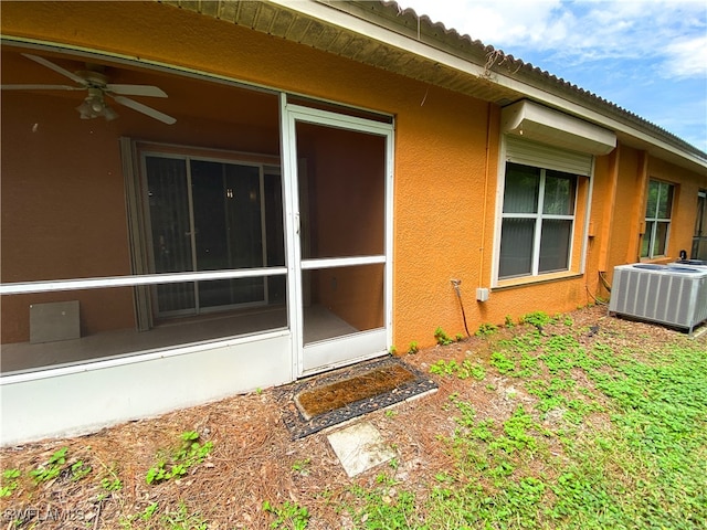 view of side of property featuring cooling unit, a sunroom, and ceiling fan