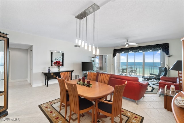 tiled dining area featuring ceiling fan and a textured ceiling