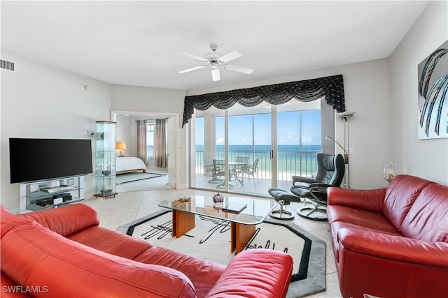 living room with a water view and ceiling fan