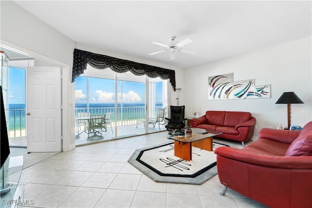 tiled living room featuring a water view and ceiling fan