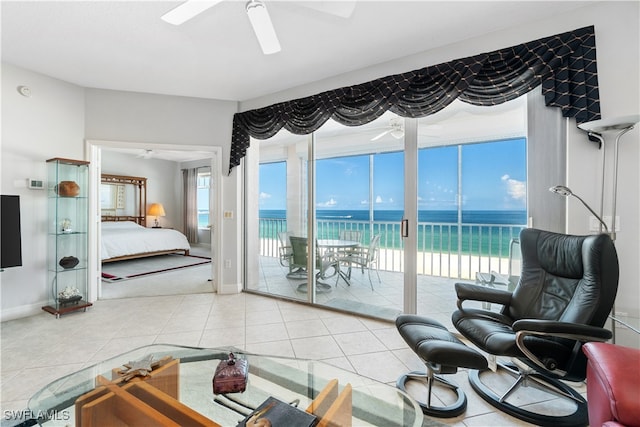 tiled living room with a water view and ceiling fan