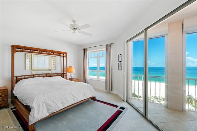 carpeted bedroom with ceiling fan, a water view, access to exterior, and multiple windows