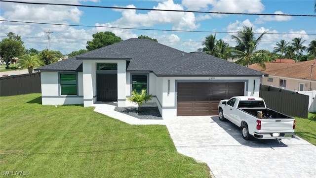 view of front of property featuring a front yard and a garage