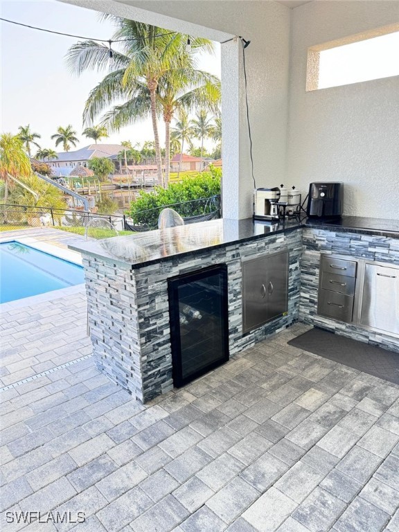 view of patio featuring wine cooler and exterior kitchen