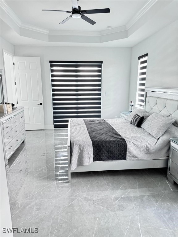 bedroom featuring ceiling fan, a tray ceiling, and ornamental molding