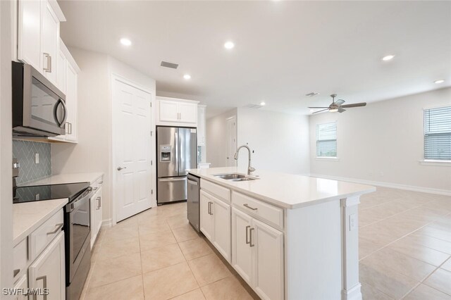 kitchen featuring sink, stainless steel appliances, a healthy amount of sunlight, and an island with sink