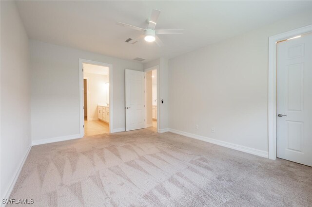 unfurnished bedroom featuring ceiling fan, light carpet, and connected bathroom