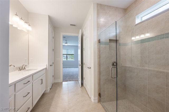 bathroom with tile patterned flooring, vanity, an enclosed shower, and a wealth of natural light