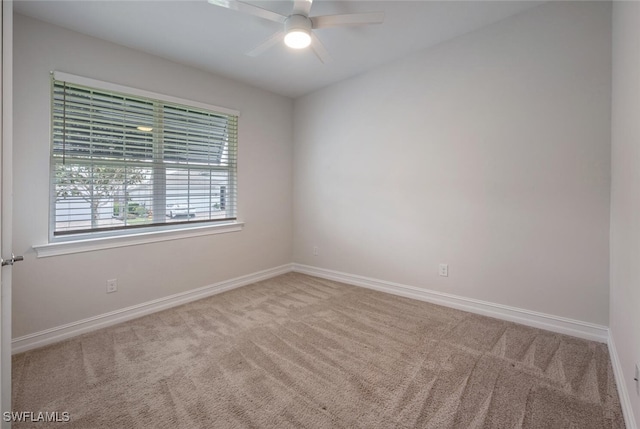 carpeted spare room featuring ceiling fan