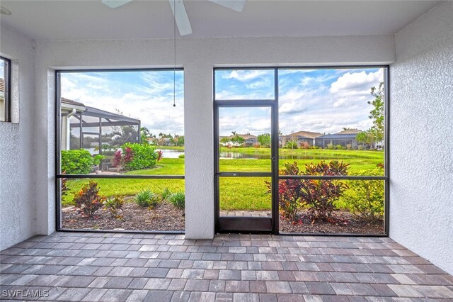 unfurnished sunroom with ceiling fan and plenty of natural light