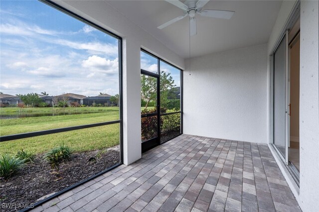 unfurnished sunroom featuring ceiling fan