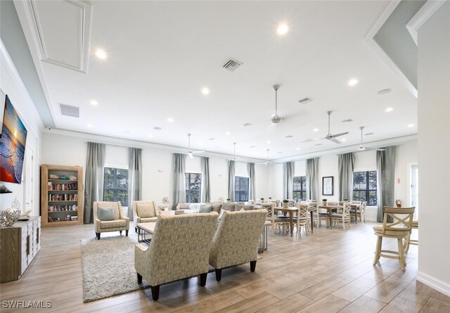 living room featuring ceiling fan, crown molding, and light hardwood / wood-style floors