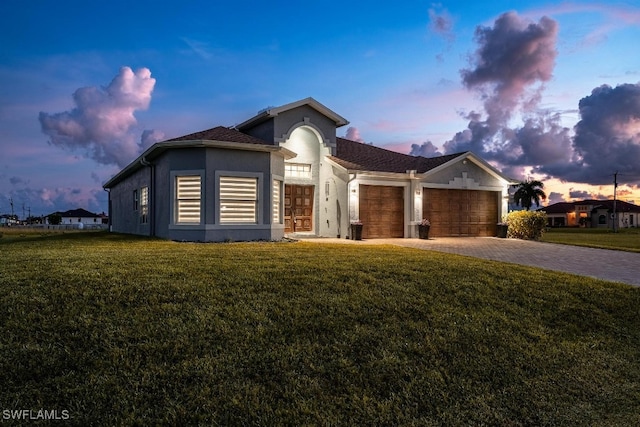 view of front of house with a garage and a yard