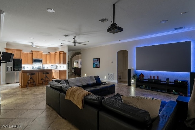 tiled living room with ornamental molding and ceiling fan