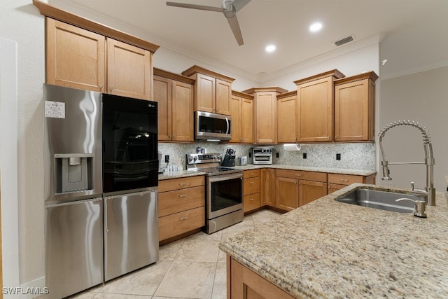 kitchen with ornamental molding, ceiling fan, appliances with stainless steel finishes, and sink